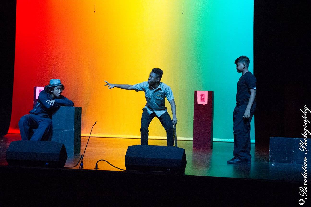 The Inspector (Daniel Baptiste) tells a story about three men in Simeon Moodoo's "The Inspector" (2016) at Naparima Bowl | Photo credit: Revolution Photography