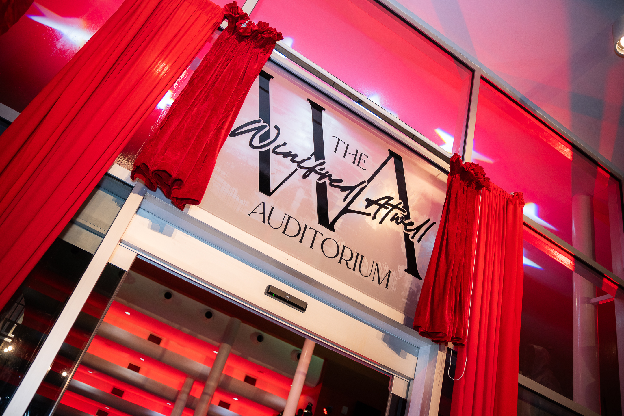 The unveiling of the Dedication Plaque and Building Signature at Queen's Hall's Winifred Atwell Auditorium Naming Ceremony. Photo credit: Stephen Dalchan